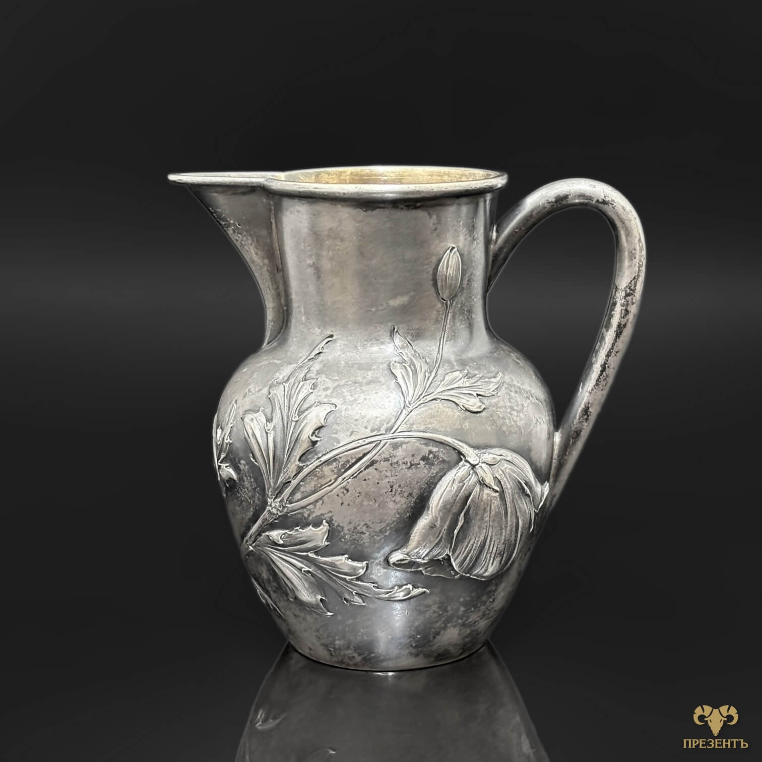 Элегантный серебряный кувшин с объёмным декором и плавными линиями
